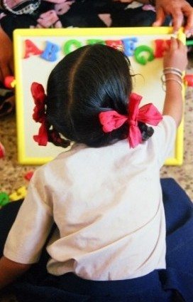 girl playing with magnetic letters