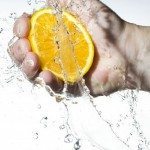 Hand squeezing juice out of an orange